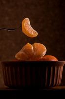 sliced naartjie being lifted out of a bowl
