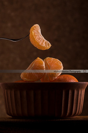 sliced naartjie being lifted out of a bowl