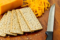 Yellow cheddar cheese and crackers on a wooden background