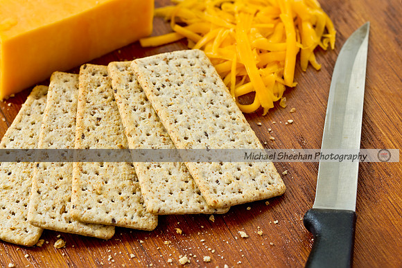 Yellow cheddar cheese and crackers on a wooden background